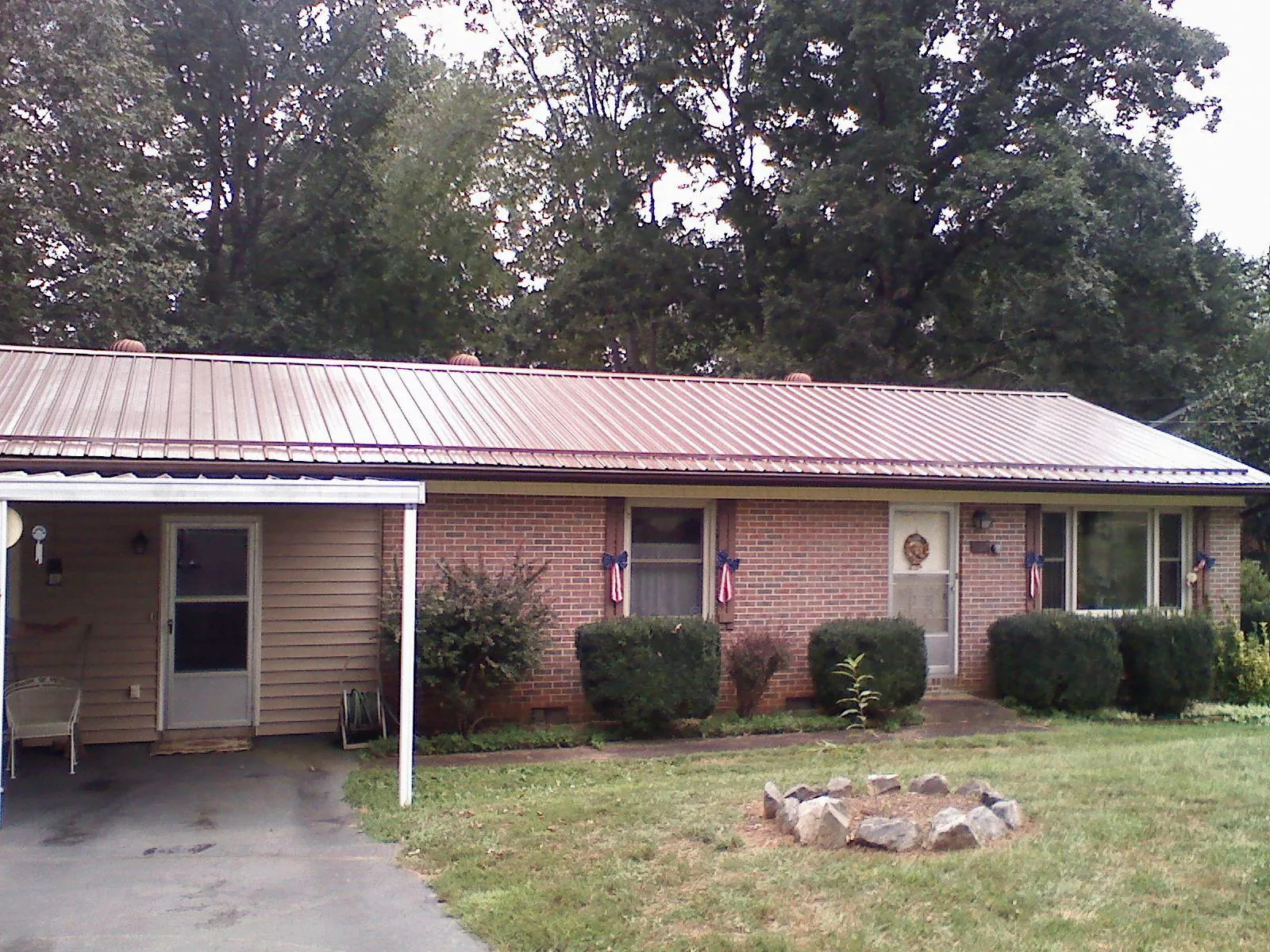 Bronze metal roof and carport on a brick ranch home — Roof Repair work by our crew in Calhoun